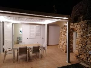 a dining room with a table and chairs at Callistos Trullo Torre Vado in Marina di Pescoluse