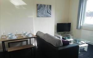 a living room with a couch and a table at Carvetii - Walter House - First floor flat sleeps 6 in Leslie