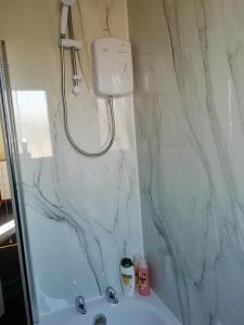 y baño con ducha y pared de mármol. en Carvetii - Walter House - First floor flat sleeps 6, en Leslie