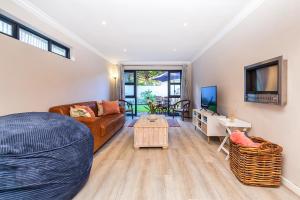 a living room with a couch and a table at Seacrest Cottage in Knysna