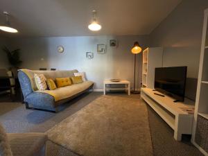 a living room with a couch and a television at Westend Holiday Let 2 Brecon in Brecon