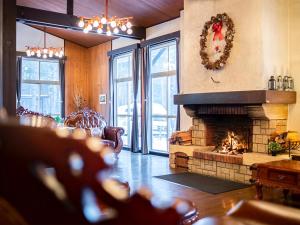- un salon avec une cheminée et une couronne de Noël dans l'établissement HOLIDAY VILLA Hotel & Resort KARUIZAWA, à Tsumagoi