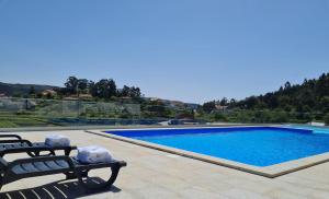 una piscina con 2 sillas de jardín junto a ella en Paraiso Do Gabriel, 