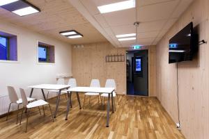 a conference room with tables and chairs and a flat screen tv at Russkiy Dom in Longyearbyen