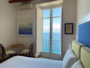 a bedroom with a bed and a view of the ocean at Casa a Mare in Sorrento