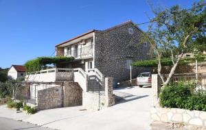 a stone house with a car parked in front of it at Retro room-Otok Vis in Podstražje
