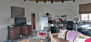 a living room with a couch and a kitchen at Blackbrook Farm Underberg in Underberg