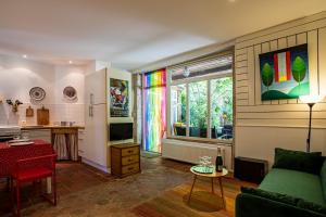 a living room with a green couch and a window at L'Atelier du Relais in Laives