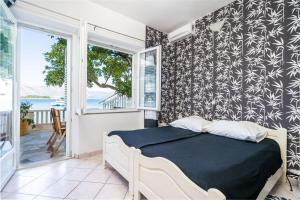 1 dormitorio con 1 cama y balcón en Apartments Nikolina en Lumbarda