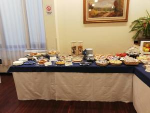 een tafel met veel verschillende soorten gebak erop bij Hotel Kursaal BB in Salsomaggiore Terme