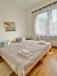 1 dormitorio con 1 cama grande y toallas. en Luca Apartman, en Gyenesdiás