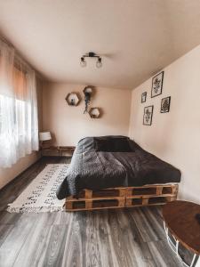1 dormitorio con 1 cama y suelo de madera en Domek pod Lawędą, Roztocze, 