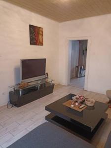 sala de estar con TV de pantalla plana y mesa de centro en appartement de 70m2 tout équipé, en Hargarten-aux-Mines
