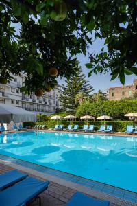 a large swimming pool with chairs and umbrellas at Aequa Hotel in Vico Equense