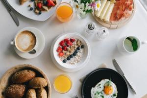 uma mesa coberta com pratos de alimentos e bebidas ao pequeno-almoço em Hotel Fronza em Luttach