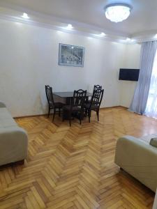 ein Wohnzimmer mit einem Tisch, Stühlen und einem Sofa in der Unterkunft Apartment On 26 May Str in Batumi