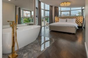 a bedroom with a tub and a bed and a bed and a bed at St Palace Hotel in Vilnius