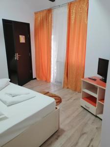 Zimmer mit 2 Betten und einem Schreibtisch mit einem Computer in der Unterkunft Pensiunea Denisa in Săcăluşeşti