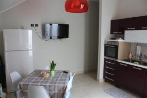 a small kitchen with a table and a white refrigerator at TETI Rooms in Francavilla Fontana