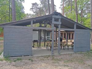 einem blauen Schuppen mit einem Tisch und Stühlen in der Unterkunft Ośrodek Wypoczynkowy Leśny Zakątek in Sieraków