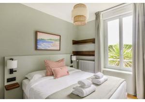 a bedroom with a bed with towels on it at Hôtel Restaurant Le Cap in Barneville-Carteret