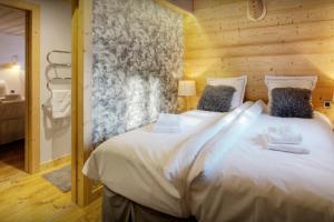 a bedroom with a large white bed in a room at Chalet Victorina - OVO Network in La Giettaz