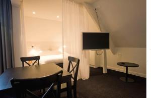 Pokój ze stołem i sypialnią z łóżkiem w obiekcie Quarante Cinq w mieście Evergem