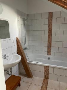 ein Badezimmer mit einem Waschbecken und einer Badewanne in der Unterkunft Kaiserhof Goldenbek in Goldenbek
