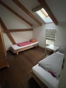 a attic room with two beds and a window at Kaiserhof Goldenbek in Goldenbek