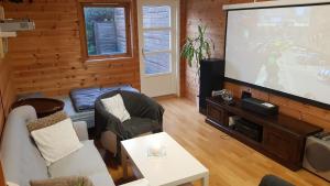 sala de estar con TV de pantalla plana y sala de estar. en One-room cabin without shower en Time