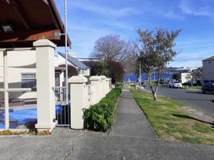 una cerca blanca frente a una casa en Apartment Fourteen en Taupo