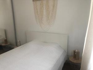 una camera con un letto bianco e una finestra di Appartement 5 étoiles charmant et cosy a Canet-en-Roussillon