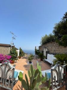 patio con sedie, tavolo e alcune piante di Casa a Mare a Sorrento