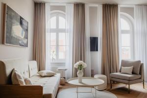 a living room with a couch and a chair and a table at Hotel Schloss Teutschenthal in Teutschenthal