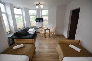 a living room with two beds and a couch at HUZAR in Krynica Zdrój