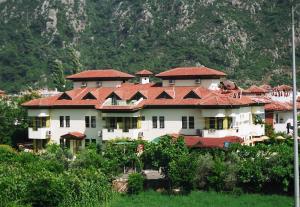a large building with red roofs on a mountain at ÖZ-AY APART OTEL in Marmaris
