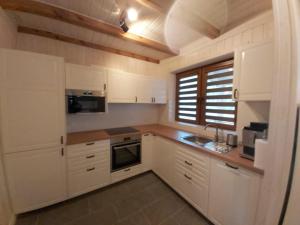a small kitchen with white cabinets and a window at Domek Paralotniarza in Borsk