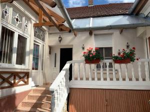 ein weißes Haus mit zwei Topfblumen auf einer Veranda in der Unterkunft Edit Villa in Balatonfüred