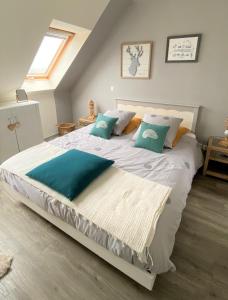 a bedroom with a large white bed with blue pillows at TY CAÏRN - PORTE DU CROUESTY in Arzon