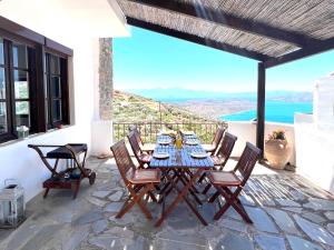 a table and chairs on a patio with a view of the ocean at Beautiful Villa Helios with stunning sea view! in Vrouhas
