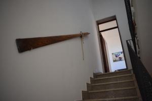 a stairway with a wooden beam on the wall at Ponente & Maestro Rooms in Favignana