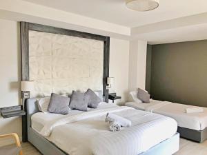 a bedroom with two beds with towels on them at Assasa Huahin in Hua Hin
