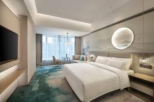 Voodi või voodid majutusasutuse Shenzhen Grand Skylight Garden Hotel toas