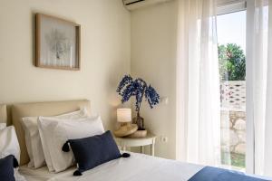 a bedroom with a bed and a window at Azure Beach Villas in Kissamos
