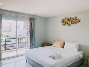 a bedroom with a bed and a large window at Assasa Huahin in Hua Hin