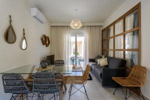 a living room with a couch and a table and chairs at Azure Beach Villas in Kissamos