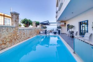 a swimming pool in a house with a stone wall at Alexis Hotel in Chania