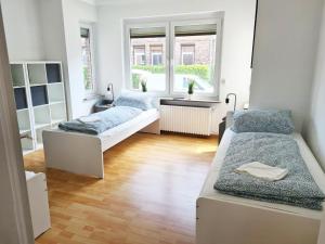 two beds in a room with two windows at 3 room flat with terrace and garden in Celle
