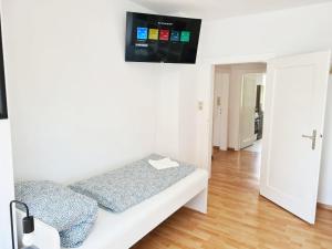 a room with a couch with a tv on the wall at 3 room flat with terrace and garden in Celle