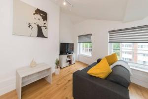 uma sala de estar com um sofá e uma mesa em Lovely 1-BDR w/ free parking in central Reading em Reading